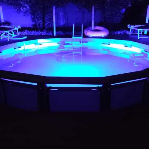 Piscina con rivestimento e pavimentazione in legno - notte